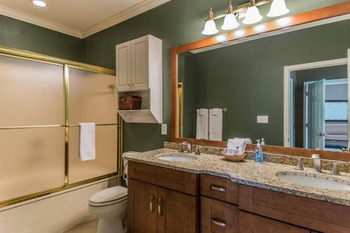 La salle de bains est pourvue de 2 lavabos, de toilettes et d'un miroir. dans l'établissement Picture perfect Marina Cove Escape with magnificent lake views, à Greensboro