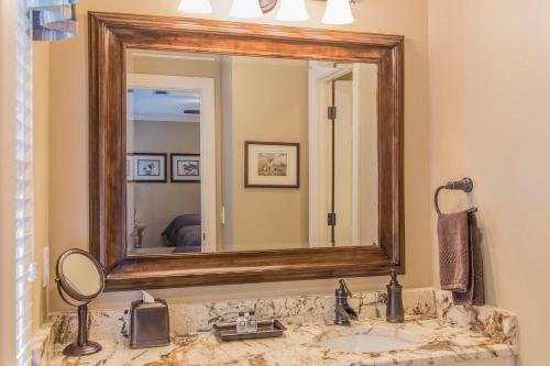 La salle de bains est pourvue d'un lavabo et d'un miroir. dans l'établissement Park Place Great Waters Lakeside cottage, à Turnwold
