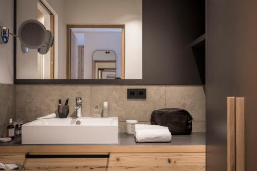 a bathroom with a white sink and a mirror at Aparthotel Gamz in Sesto