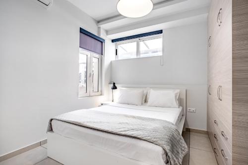 1 dormitorio blanco con 1 cama y 2 ventanas en Supreme B1 Apartment in Syntagma en Athens