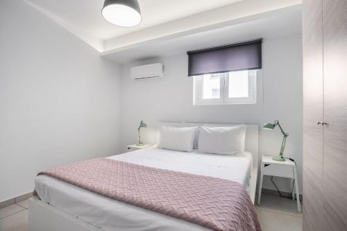 ein weißes Schlafzimmer mit einem Bett und einem Fenster in der Unterkunft Supreme C1 Apartment in Syntagma in Athen