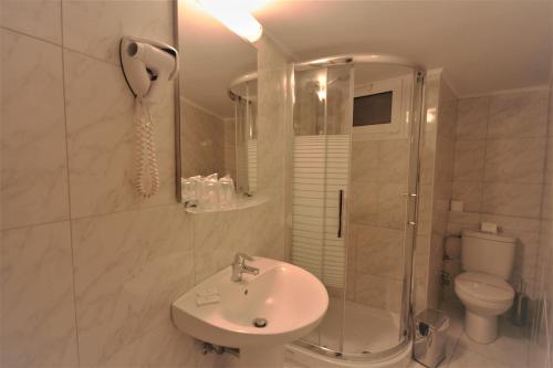 a bathroom with a shower, toilet and sink at Adam's Hotel in Athens