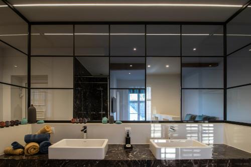 La salle de bains est pourvue de 2 lavabos et d'un grand miroir. dans l'établissement Hofstede Ter Biest, à Zwalm