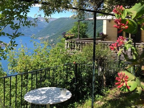 a table on a balcony with a view of a lake at B&B Villa le Ortensie in Faggeto Lario 