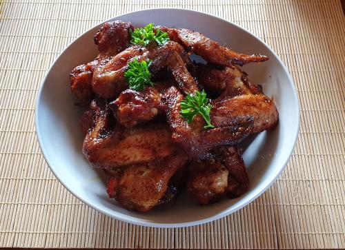 a white bowl of chicken wings with parsley on it at Penzion U Dvou pánů in Pernink