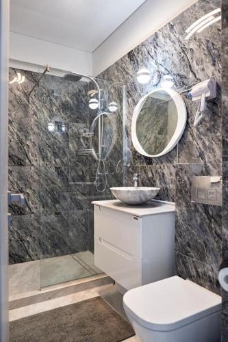 a bathroom with a sink and a toilet and a mirror at 5 stars 301 frontal sea view apartment in Mamaia Sat/Năvodari