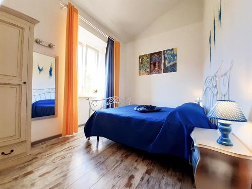 sypialnia z niebieskim łóżkiem i oknem w obiekcie DIMORA IL CAMALEONTE, apartments in nature near the sea w mieście Civitavecchia