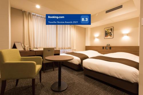 a hotel room with two beds and a desk at Osaka Riverside Hotel in Osaka