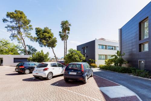 two cars parked in a parking lot next to a building at Daniya Alicante in Alicante