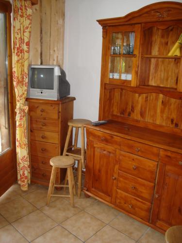 a room with a tv and a wooden dresser with a tvicterictericter at Appartement idéal été ou hiver, pour skieurs et promeneurs, 4 personnes in Saint-Gervais-les-Bains