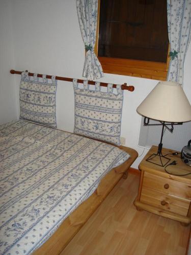 Ce lit se trouve dans un dortoir doté d'une lampe et d'une lampe. dans l'établissement Appartement idéal été ou hiver, pour skieurs et promeneurs, 4 personnes, à Saint-Gervais-les-Bains