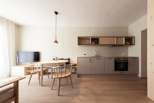 a kitchen and dining room with a table and chairs at Mondschein Apartments in Lana
