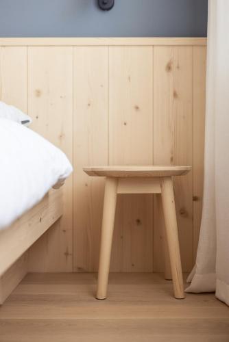 a small wooden table in a room with a bed at Mondschein Apartments in Lana