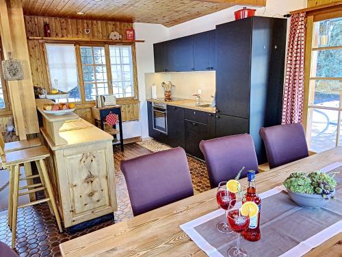 cocina con mesa de madera y sillas moradas en Chalet Belle Poncke, en Nendaz