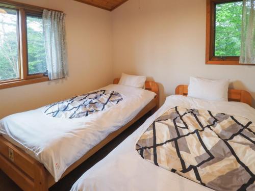 2 Einzelbetten in einem Zimmer mit 2 Fenstern in der Unterkunft Nasu-gun - House - Vacation STAY 8981 in Shiozawa