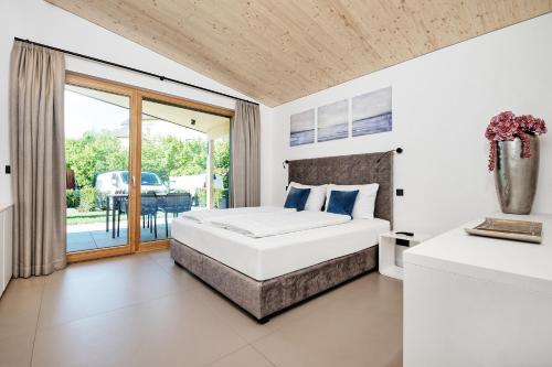 um quarto com uma cama e uma varanda em Privates Ferienhaus Velden 24 Home em Velden am Wörthersee