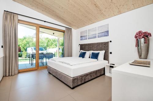 a bedroom with a bed and a balcony at Privates Ferienhaus Velden 24 Home in Velden am Wörthersee