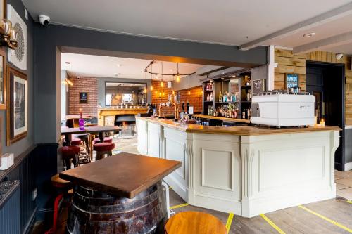 a bar in a pub with a table and chairs at The Lazy Pug in Shipston-on-Stour