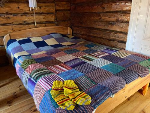 a bed with a colorful quilt on top of it at Bondari - countryside experience near Rēzekne in Reiki