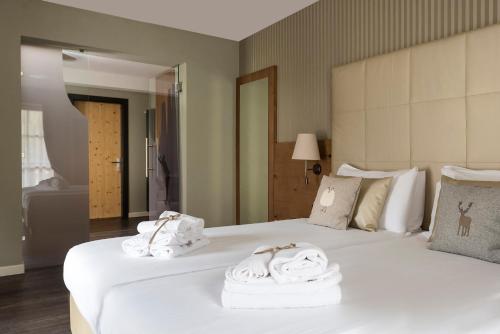 a hotel room with two beds with towels on them at X Alp Hotel in Pozza di Fassa