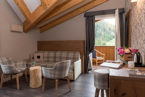 a living room with a couch and chairs and a table at X Alp Hotel in Pozza di Fassa