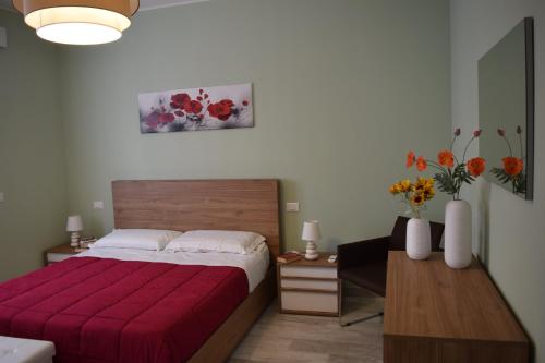 a bedroom with a bed with a red blanket at Il Portico in Peschiera del Garda