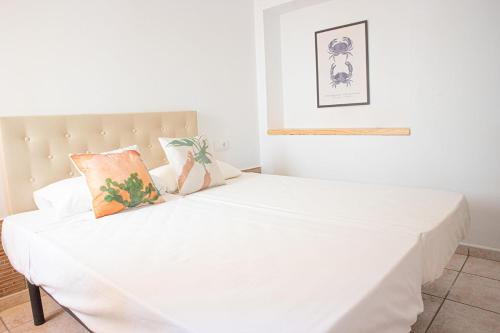 1 dormitorio con cama blanca y cabecero en Salitre Rooms, en Conil de la Frontera