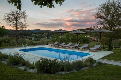 una piscina con sillas y sombrillas en un patio en Puhek breg, en Krapina