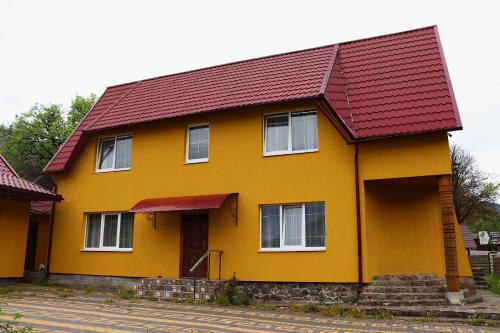 a yellow house with a red roof at Сільська Садиба in Kvasy