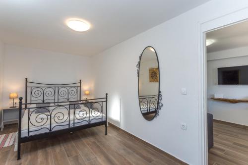 een kamer met een bed en een spiegel aan de muur bij NoMADS in Hvar