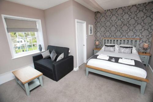 a bedroom with a bed and a chair at Glyn Valley Hotel in Llansantffraid Glyn Ceiriog