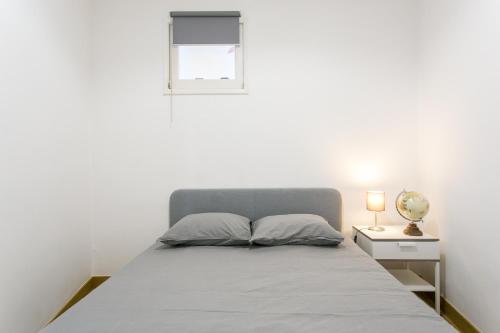 a bedroom with a bed and a window and a lamp at Cozy Flat at Lisboa in Lisbon