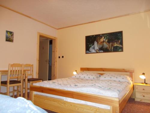 a bedroom with a bed and a painting on the wall at pension TARA in Teplice nad Metují
