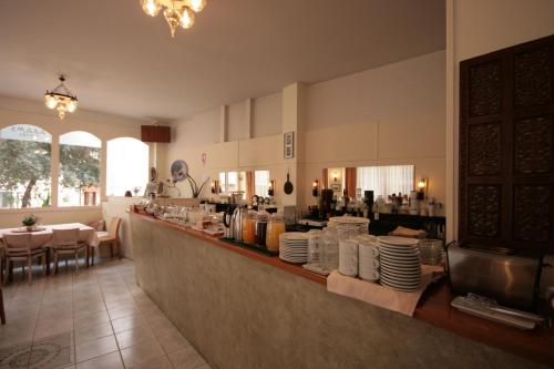 a restaurant with a counter with plates on it at Adams Hotel in Athens