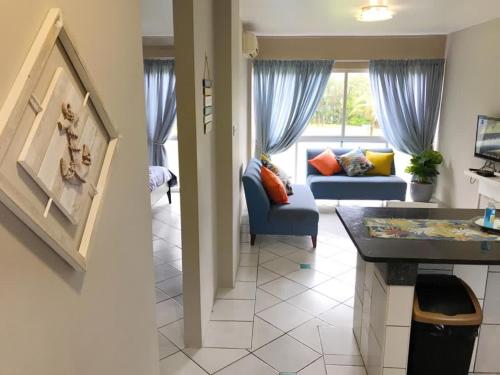 Una cocina y una sala de estar con un sofá azul. en LA Ballito, en Ballito