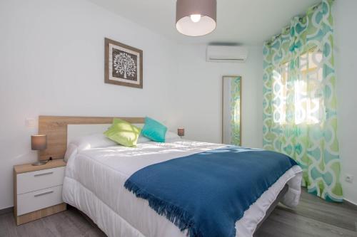 1 dormitorio con 1 cama grande con manta azul en Santa Amalia 18 by IVI Real Estate, en Torremolinos