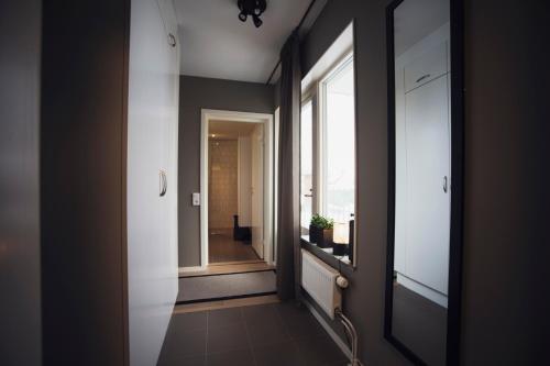a hallway with a window and a view of a room at Sky Hotel Apartments, Hospitalstorget in Linköping
