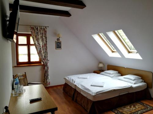 1 dormitorio con 2 camas, mesa y tragaluces en Giszowiec Pokoje gościnne Przyjazna 9 en Katowice