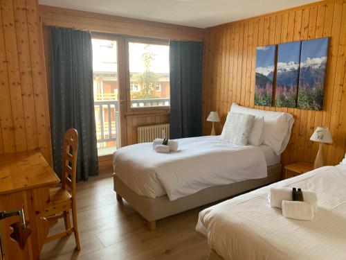 a hotel room with two beds and a balcony at Corbassière 32 in Verbier