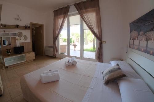 sypialnia z dużym łóżkiem z ręcznikami w obiekcie Li Carlucci w mieście Cannole