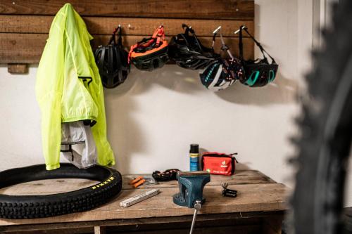 a wooden table with a tire and helmets hanging on a wall at Apartment Dui Residence Bun Ste in San Vigilio Di Marebbe