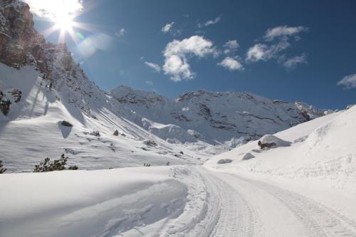 a snow covered mountain with the sun in the sky at Apartment Cinch Residence Bun Ste in San Vigilio Di Marebbe