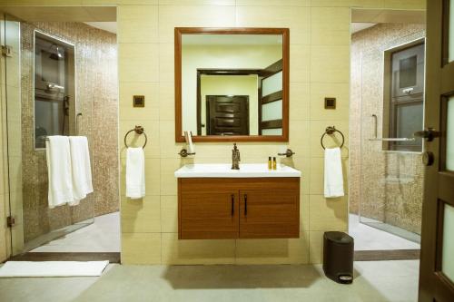 a bathroom with a sink and a mirror at Hunters Paradise Cottages in Bungoma