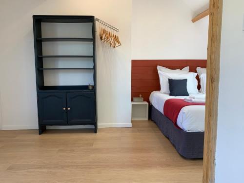 a bedroom with a bed and a black cabinet at Villa les Voiles - Chambres d'hôtes in Wimereux