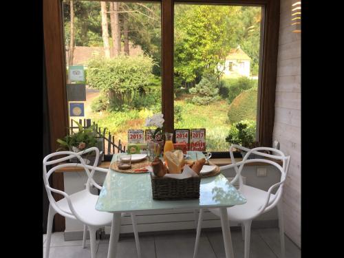 une table avec un panier de nourriture et une fenêtre dans l'établissement Greenfield Chambres d'Hôtes, à Neufchâtel-Hardelot