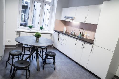 a kitchen with a table, chairs and a refrigerator at Chopin Host in Katowice