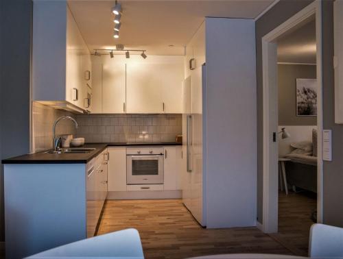 a kitchen with white cabinets and a sink at Sky Hotel Apartments Valla Berså in Linköping