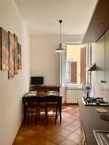 uma cozinha com mesa e cadeiras num quarto em Nice & Roomy Apartment behind the Uffizi Museum em Florença