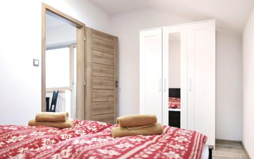 a bedroom with a red and white bed with a mirror at Apartmány pod horou in Liptovský Mikuláš