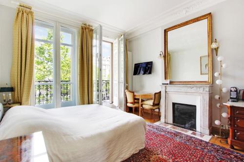 une chambre avec un lit et une cheminée dans l'établissement Suite junior avec balcon et vue sur Arc de Triomphe, à Paris